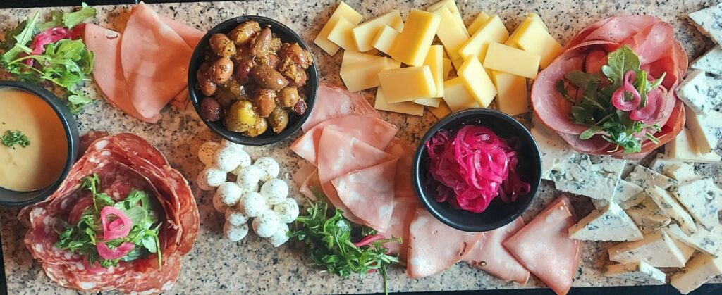 Charcuterie board with cheese, olives, meats and accompaniments